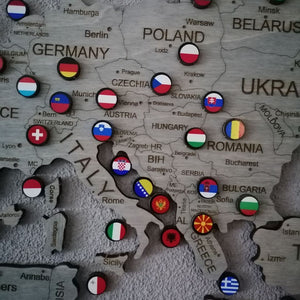 Close-up of GeoArte world flag pins set arranged on a display board with country names.