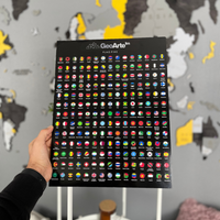 Hand holding GeoArte flag pins organizer with colorful country flags, world map in the background.